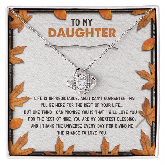 The Daughter-My Greatest Blessing - Love Knot Necklace, featuring an interlocking design and adorned with cubic zirconia crystals, is beautifully presented on a message card decorated with autumn leaves. The card reads, "To my daughter, Life is unpredictable...thank the universe every day for giving me the chance to love you.