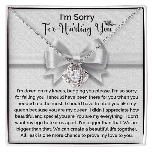 The "Sorry-My Queen - Love Knot Necklace" features a knot-shaped pendant adorned with cubic zirconia crystals and comes in a gift box that includes an apology message, expressing regret and asking for forgiveness and another chance to prove love.