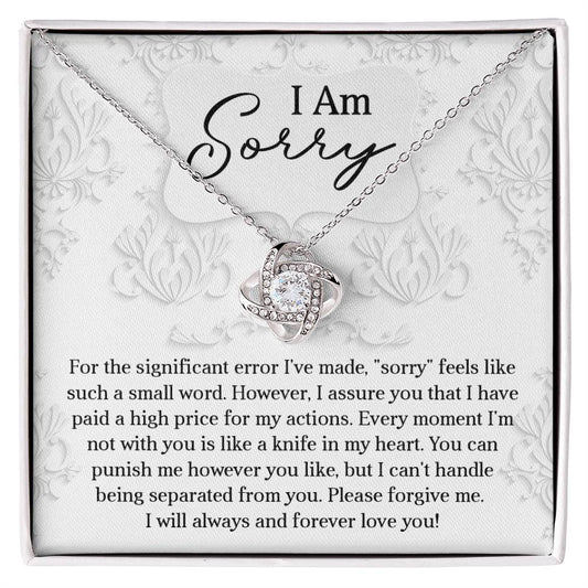 The Sorry-Forever Love You - Love Knot Necklace is elegantly displayed above a heartfelt apology letter that conveys deep remorse and enduring affection, seeking forgiveness. This exquisite piece is crafted in 14k white gold and adorned with sparkling cubic zirconia.