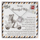 A 14k white gold To Wife, Be The One - Love Knot Necklace with cubic zirconia crystals is placed on a card depicting a couple on a scooter. The card features a heartfelt message to a wife, expressing love and commitment.