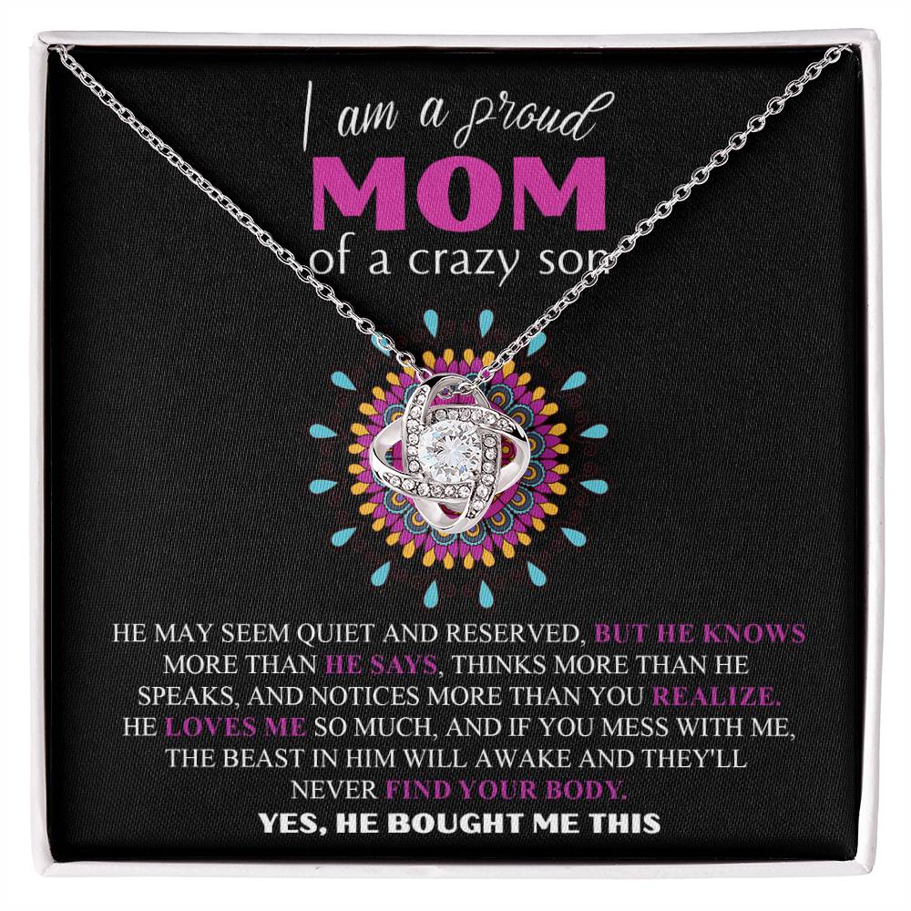 A jewelry gift box displays the "To Mom, Proud Mom - Love Knot Necklace," crafted in 14k white gold and adorned with cubic zirconia crystals. The box reads: "I am a proud MOM of a crazy son. He may seem quiet and reserved, but he knows more than he says... Yes, he bought me this.