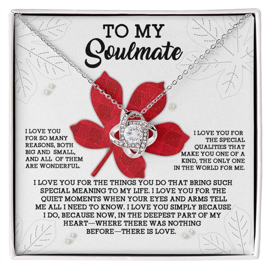 A personalized gift, the Soulmate-There Is Love - Love Knot Necklace showcases an interlocking heart pendant adorned with cubic zirconia crystals. It is presented on a card that reads "To My Soulmate" with a heartfelt message about love and appreciation set against a red flower background.