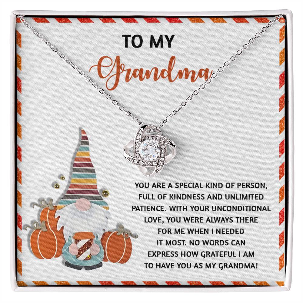 The Grandma-Needed It Most - Love Knot Necklace, embellished with cubic zirconia, is beautifully presented in a gift box featuring a touching message for grandma. The backdrop includes a charming illustration of a gnome and pumpkins, making it the ideal personalized gift for any occasion.