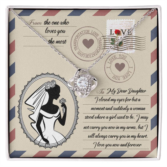 A To Daughter Wedding, In My Arms - Love Knot Necklace with a heart-shaped pendant on a card with a vintage design, featuring cubic zirconia crystals, a silhouette of a woman in a wedding gown, and a heartfelt message addressed to a daughter.