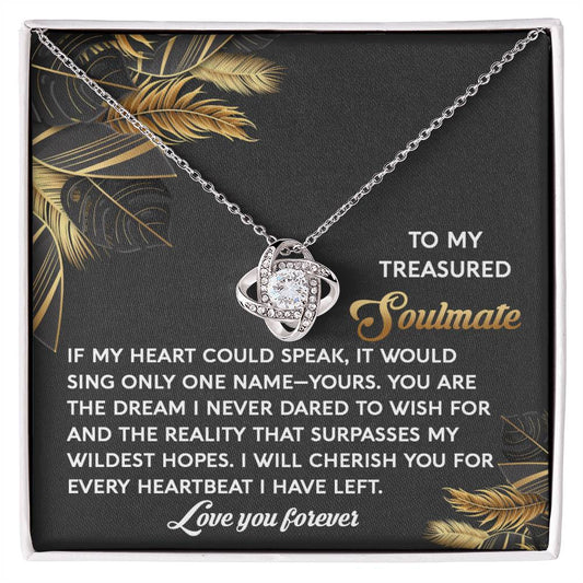 The Soulmate-Wildest Hopes Love Knot Necklace features shimmering cubic zirconia crystals on interlocking loops. It's presented on a card with a gold leaf design, capturing the essence of an unbreakable bond with the message "Love you forever.