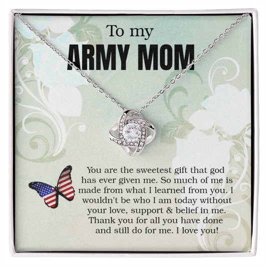 A "To My Army Mom, You Are The Sweetest Gift That God Has Ever Given Me" Love Knot Necklace with a heart-shaped pendant, adorned with cubic zirconia crystals, is presented in a box with an inscription honoring a mother of a member of the army, expressing gratitude and love from ShineOn Fulfillment.