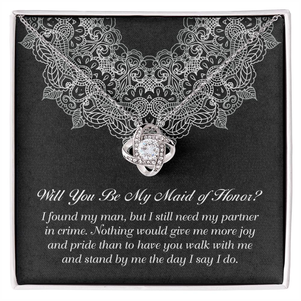 A decorative box with a "To Maid Of Honor, Partner In Crime - Love Knot Necklace" featuring a cubic zirconia; the text inside reads, "Will You Be My Maid of Honor?" followed by a heartfelt message.