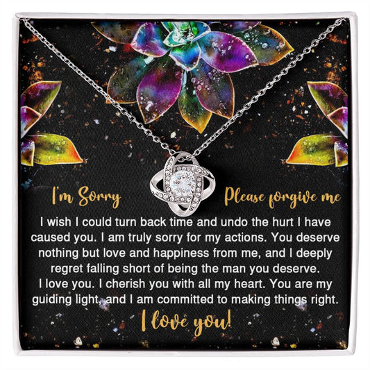 The Sorry-All My Heart - Love Knot Necklace features an interlocking heart pendant on a card with vibrant succulent graphics and the message: "I'm Sorry, Please forgive me. I love you." Adorned with sparkling cubic zirconia crystals, this necklace is available in a choice of white gold or yellow gold finish.