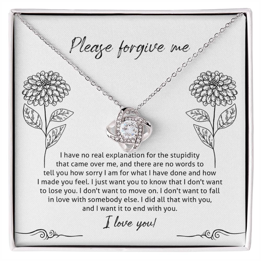 The Sorry-Real Explanation - Love Knot Necklace features an intertwined heart pendant adorned with cubic zirconia crystals, presented in a box. The box lid includes an apology note with floral illustrations, expressing regret, love, and a plea for forgiveness.