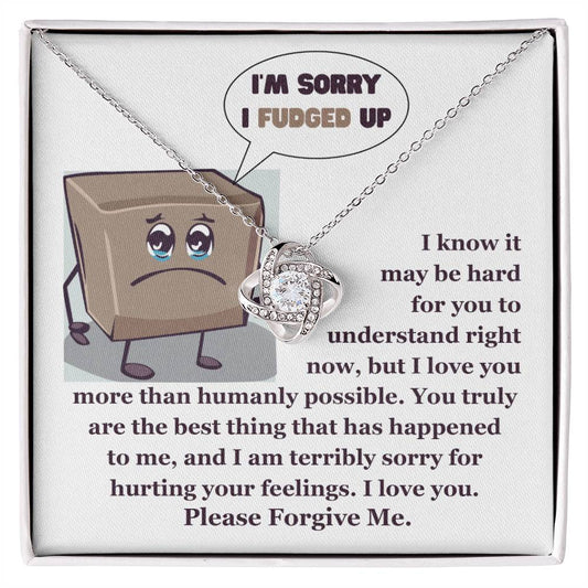 The "Sorry-The Best Thing" Love Knot Necklace, crafted in 14k white gold and adorned with shimmering cubic zirconia crystals, is presented elegantly in a box. The cover showcases an apologetic cartoon, expressing deep regret and asking for forgiveness.