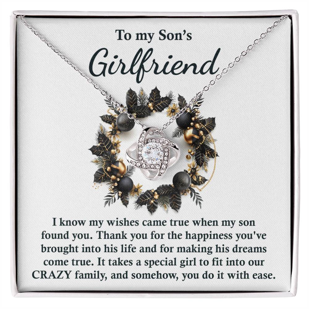 This Love Knot Necklace, titled "Son's Girlfriend - Found You," comes with a card that reads "To my Son's Girlfriend" and is adorned with a decorative floral wreath. The card conveys gratitude for her role in the family, making it a meaningful and personalized gift.