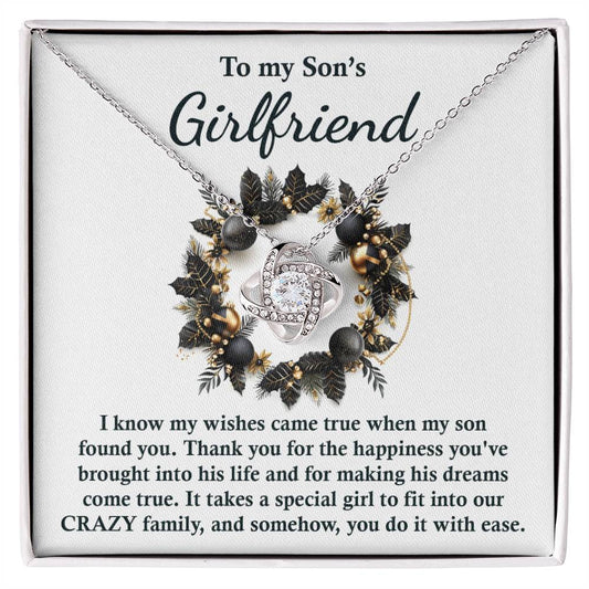 This Love Knot Necklace, titled "Son's Girlfriend - Found You," comes with a card that reads "To my Son's Girlfriend" and is adorned with a decorative floral wreath. The card conveys gratitude for her role in the family, making it a meaningful and personalized gift.