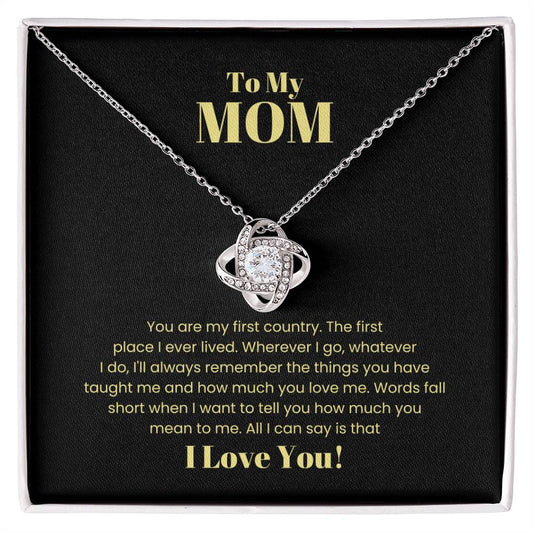To My Mom, You Are My First Country - Love Knot Necklace-shaped pendant necklace with cubic zirconia accents on a chain, in a box with a heartfelt message to mom, expressing love and gratitude.