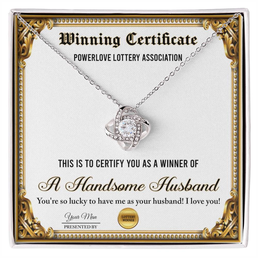 A "To Wife, Winning Certificate - Love Knot Necklace" is displayed against a certificate text background reading, "Winning Certificate - Powerlove Lottery Association - A Handsome Husband," featuring shimmering cubic zirconia crystals and an elegant gold finish.