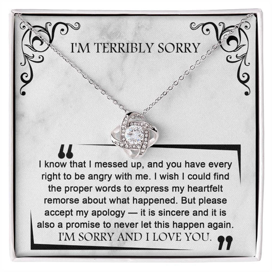 The Sorry-Angry With Me - Love Knot Necklace features an intertwined design, adorned with shimmering cubic zirconia crystals. It comes on a card that reads "I'M TERRIBLY SORRY" and includes an apology message about feeling remorseful and promising not to repeat the mistake.