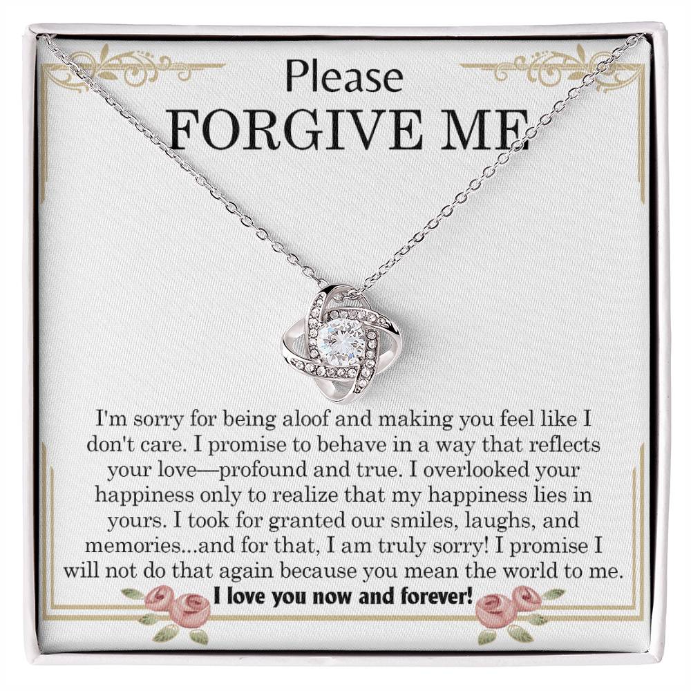 The "Sorry, Profound And True - Love Knot Necklace," featuring an intertwined heart pendant, is elegantly displayed in a box. The message "Please FORGIVE ME!" along with a heartfelt apology note is printed inside the box and beautifully accentuated by cubic zirconia crystals.