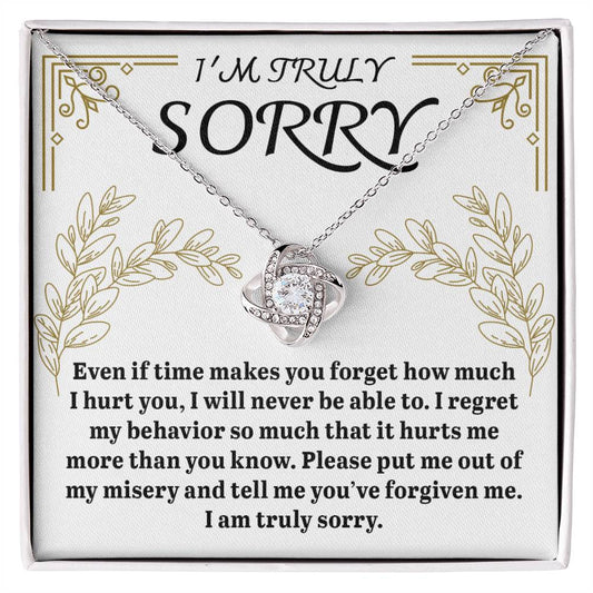 The Sorry-It Hurts Me Love Knot Necklace, crafted from 14k white gold and featuring a heart pendant, is beautifully presented in a box with the message "I'm truly sorry," along with a heartfelt apology expressing regret and seeking forgiveness.