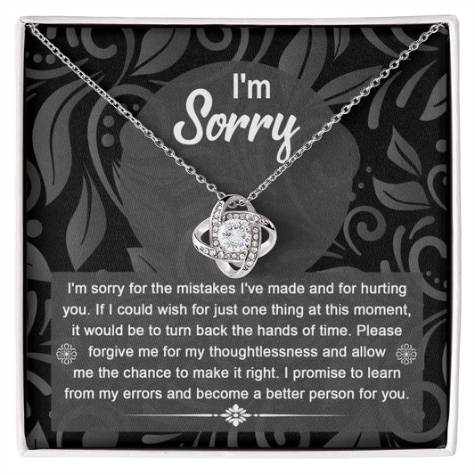 The Sorry-Just One Thing - Love Knot Necklace with intertwined loops is elegantly displayed in a box, featuring an apology message on the inside lid that reads: "I'm sorry. I'm sorry for the mistakes I've made and for hurting you...