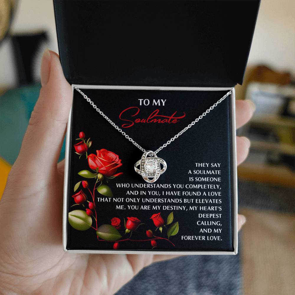 A hand holds a necklace box with a glowing Love Knot pendant. Inside, "To My Soulmate" is displayed alongside red rose graphics, making the Soulmate-Deepest Calling - Love Knot Necklace the perfect personalized gift.