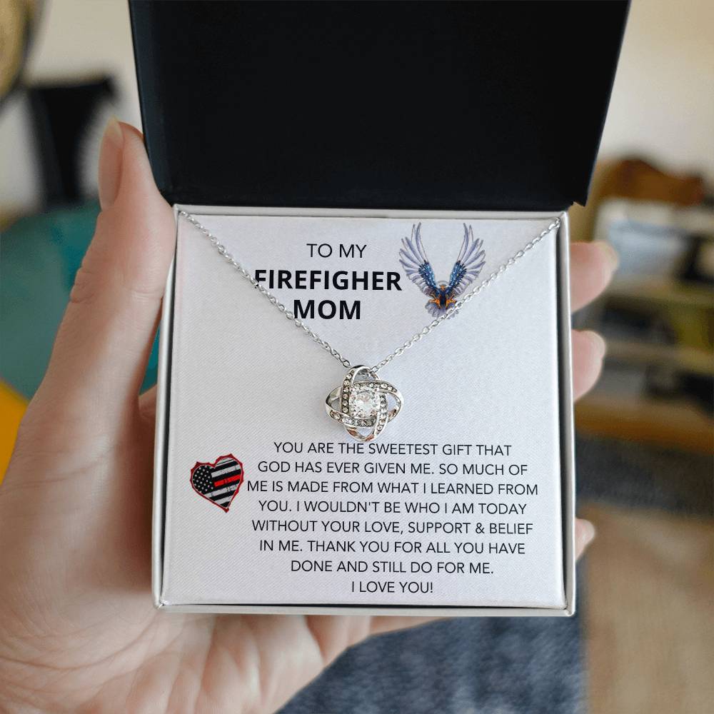 A gift box with a To Dog Mom, Pawtrick Day-A Better Life Love Knot Necklace for my firefighter mom, filled with cubic zirconia crystals from ShineOn Fulfillment.