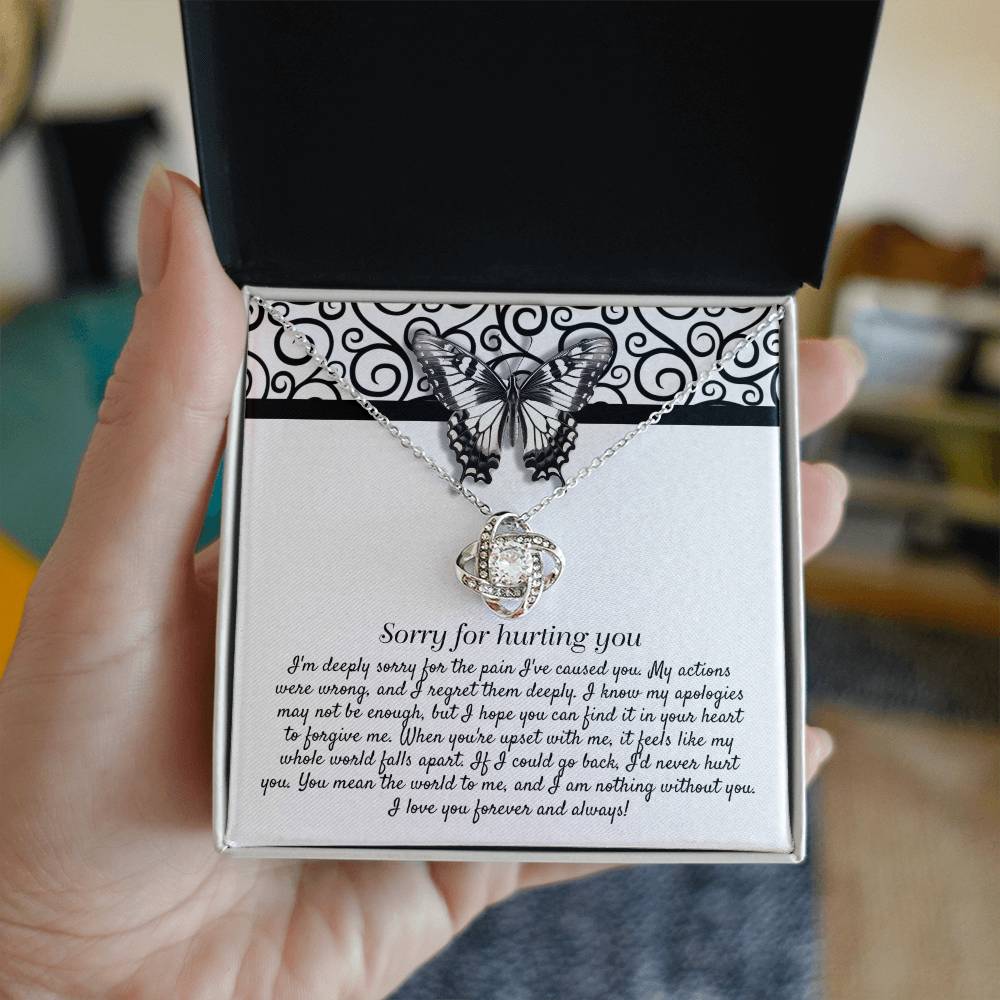 The "Sorry-Nothing Without You - Love Knot Necklace" features a heart-shaped pendant adorned with cubic zirconia crystals and is presented on a card with an apology message and a butterfly design.