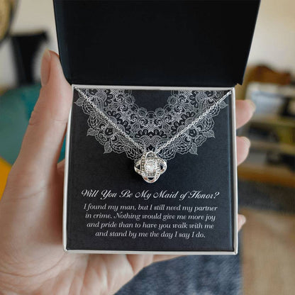 A decorative box with a "To Maid Of Honor, Partner In Crime - Love Knot Necklace" featuring a cubic zirconia; the text inside reads, "Will You Be My Maid of Honor?" followed by a heartfelt message.