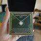 A hand holding a Happy St. Patrick Day, I'm So Lucky - Love Knot Necklace by ShineOn Fulfillment in a box.