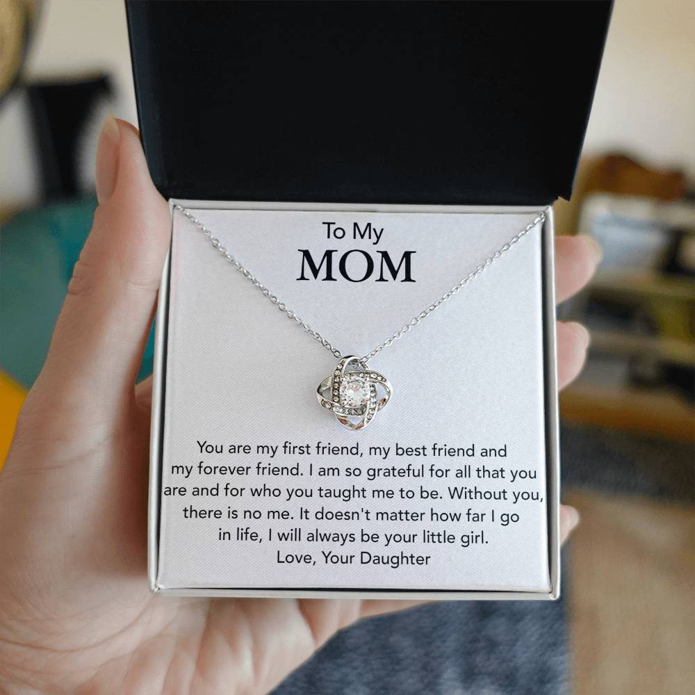 A "To My Mom, You Are My First Friend - Love Knot Necklace" by ShineOn Fulfillment is presented in an open gift box, featuring an emotional message from a daughter to her mother, expressing gratitude and love.