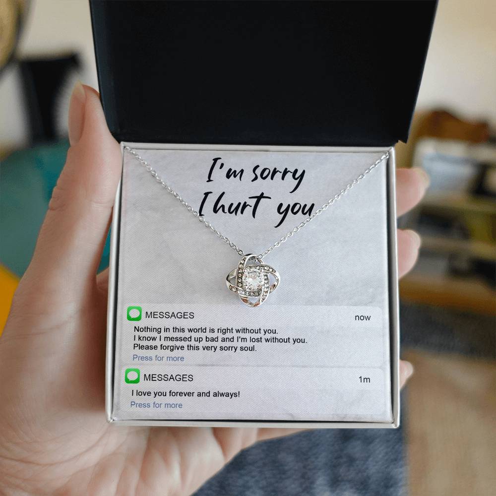 Image of the Sorry-Lost Without You - Love Knot Necklace with a diamond pendant against a background with the text "I'm sorry I hurt you." Below are text messages reading "Nothing in this world is right without you... Please forgive this very sorry soul." and "I love you forever and always!