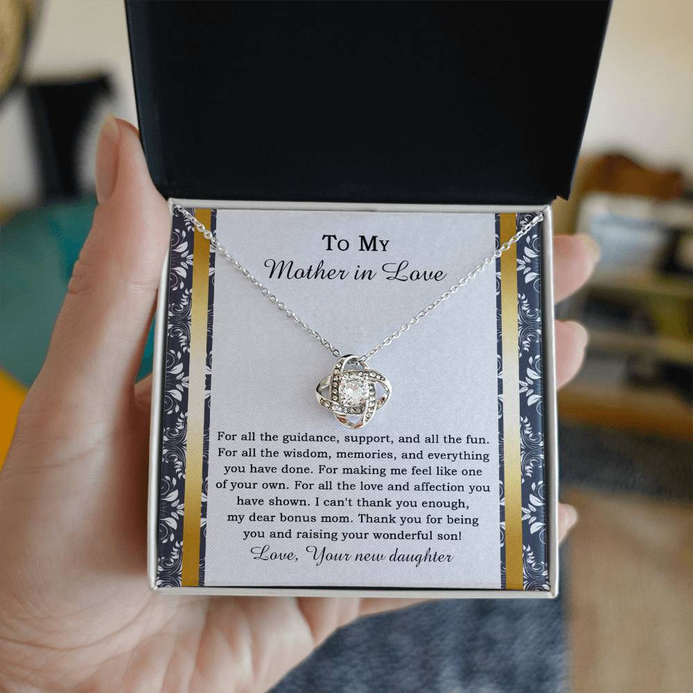 The "To Mother-in-law, Of Your Own - Love Knot Necklace" features a heart-shaped pendant adorned with cubic zirconia crystals, and it comes on a card expressing gratitude for a mother-in-law's love and support.