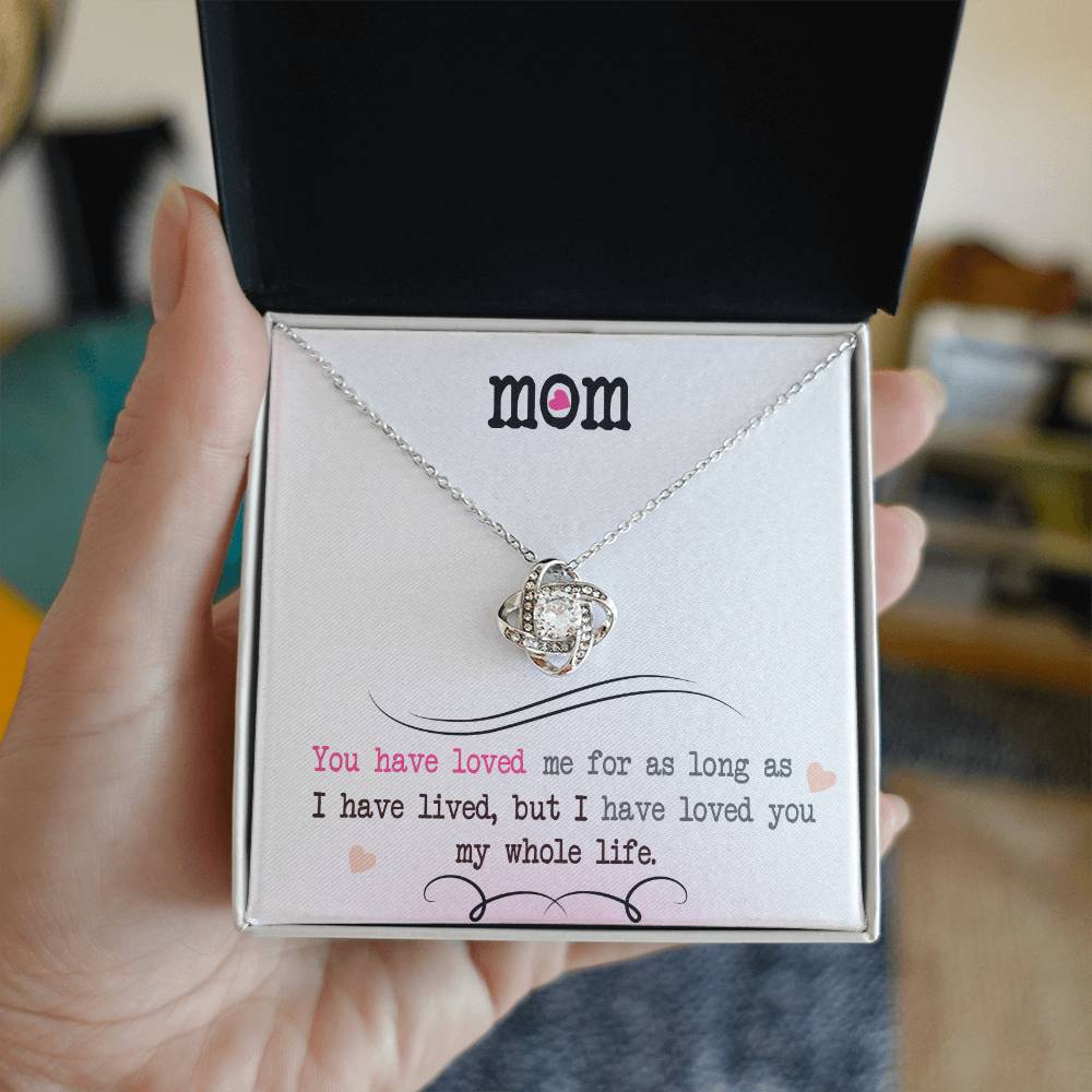 A "To My Mom, I Loved You My Whole Life" Love Knot Necklace in a gold finish, presented in a gift box accompanied by a sentimental message. Brand Name: ShineOn Fulfillment