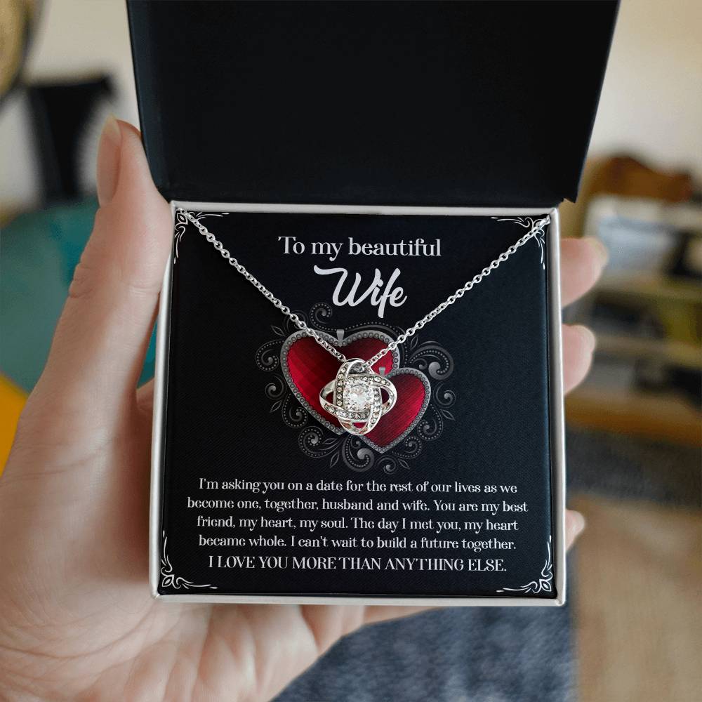 A To Wife, Heart Became Whole - Love Knot Necklace in a gift box, adorned with sparkling cubic zirconia crystals and accompanied by a heartfelt message for a wife, expressing love and a desire to build a future together.