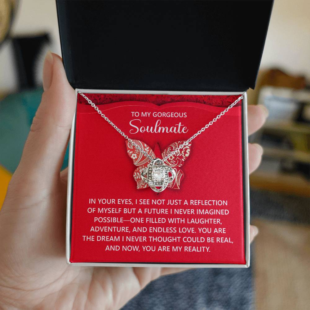 The Soulmate-My Reality Love Knot Necklace, featuring a butterfly shape and cubic zirconia crystals, is beautifully presented in a gift box. Inside, it includes the message, "To my gorgeous soulmate," with a heartfelt note below—a perfect personalized gift.