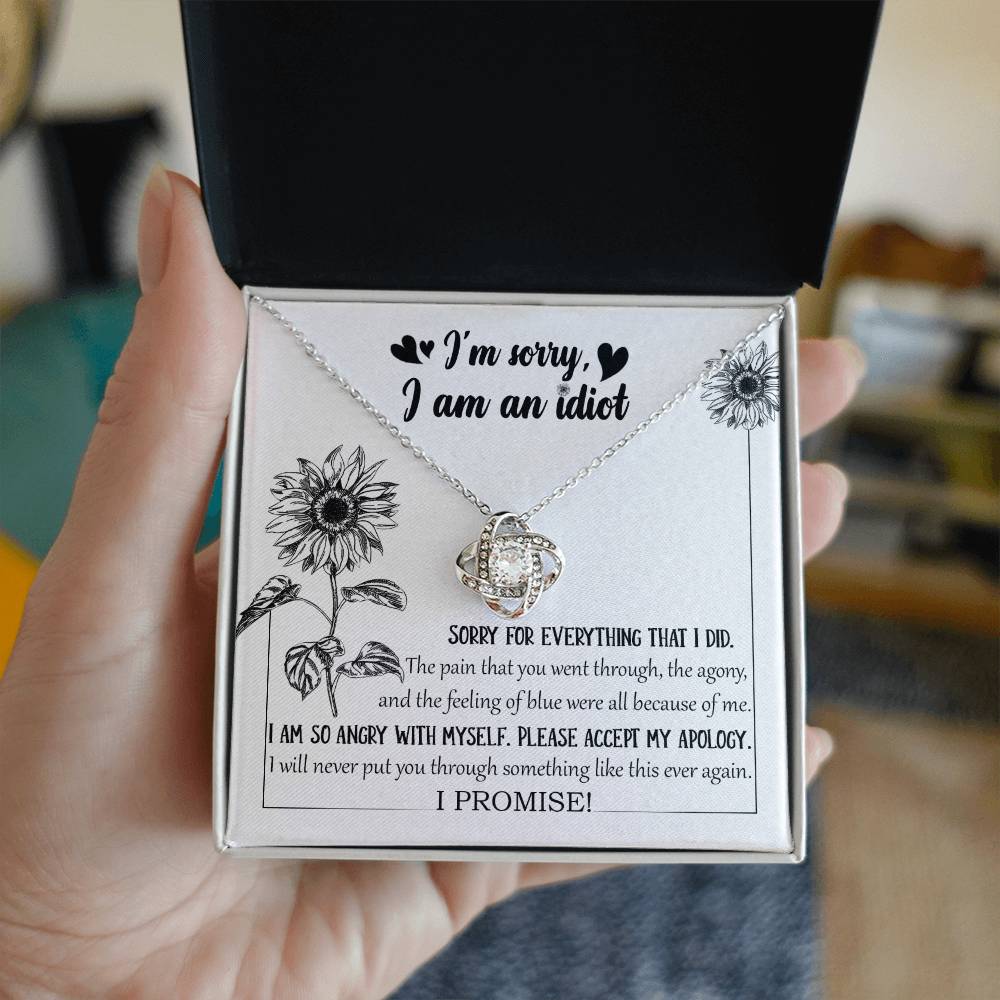 The Sorry-Feeling Of Blue - Love Knot Necklace, crafted from 14k white gold with a heart-shaped pendant adorned with cubic zirconia crystals, is displayed in a box containing an apology message, "I'm sorry, I am an idiot," along with additional text expressing regret for causing pain and a promise to not repeat the hurt.