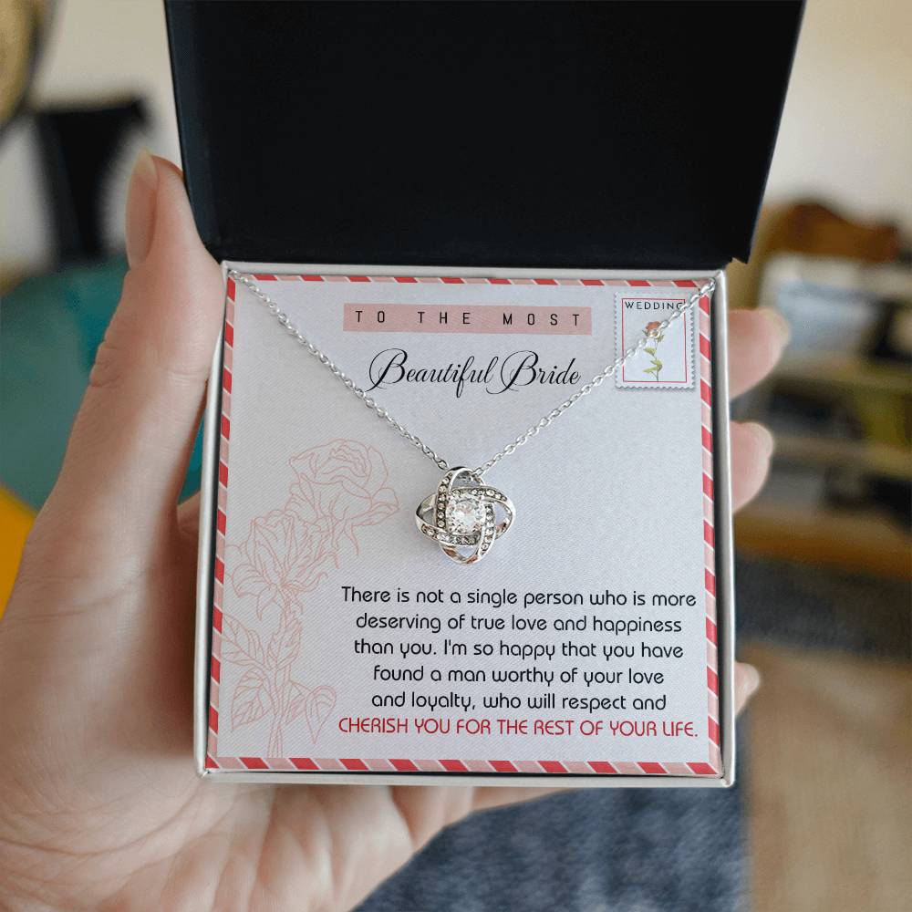 To Bride, Of Your Life - Love Knot Necklace crafted from stunning 14k white gold, featuring a knot-shaped pendant adorned with cubic zirconia crystals. Presented on a card with wedding-themed decor that reads: "To the most beautiful bride" and contains a heartfelt message below.