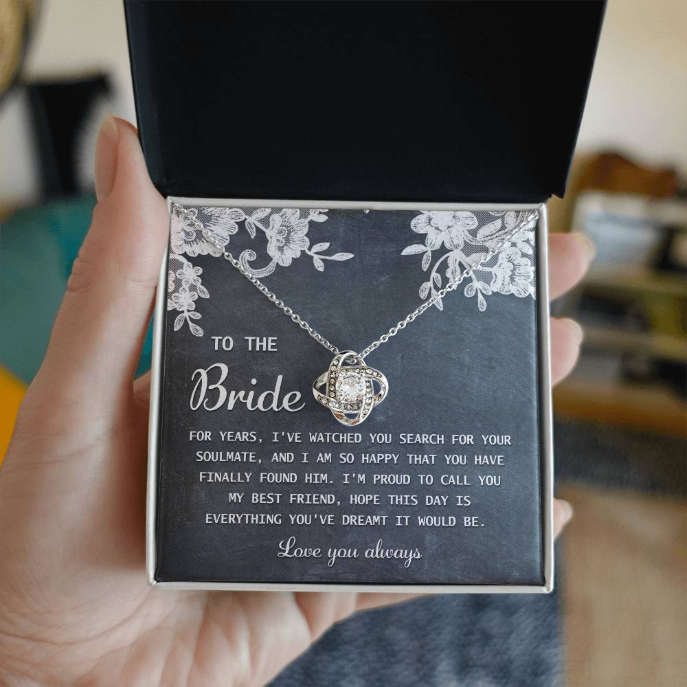 The "To Bride, My Best Friend - Love Knot Necklace" in silver, adorned with cubic zirconia crystals, is presented on a card with a sentimental message for the bride and comes in a decorated gift box.