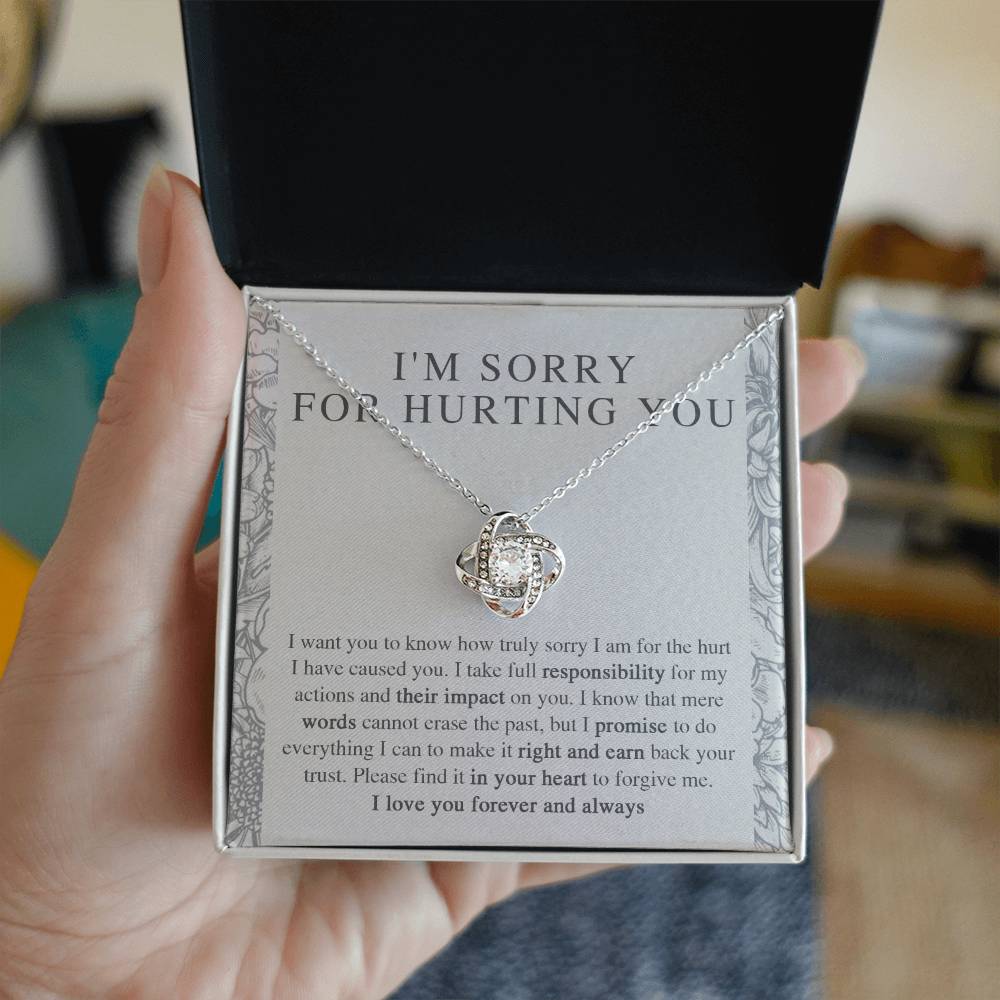 The Sorry-Do Everything - Love Knot Necklace features an eye-catching silver intertwined pendant, elegantly adorned with cubic zirconia crystals, showcased against a heartfelt printed apology message. The message conveys sincere regret, taking responsibility, and earnestly asking for forgiveness with love.