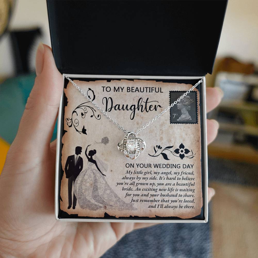 A silver To Daughter Wedding, Beautiful Bride - Love Knot Necklace adorned with cubic zirconia crystals on a card featuring an illustrated bride and groom. The card reads "To my beautiful daughter on your wedding day" with a heartfelt message.