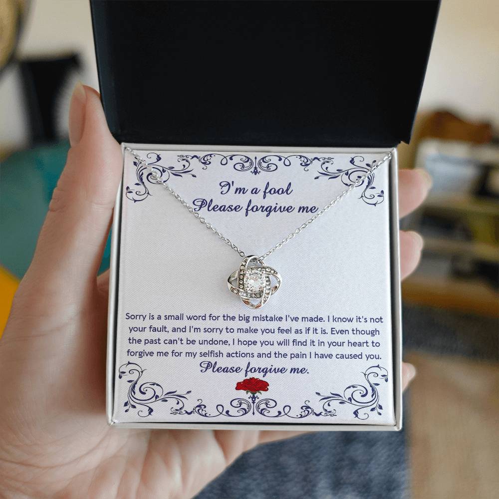 The "Sorry, I_m A Fool - Love Knot Necklace" features a 14k white gold pendant encased in a box with a heartfelt apology message. This message conveys regret and seeks forgiveness for causing pain and acting selfishly. The pendant is adorned with premium cubic zirconia crystals, adding an extra touch of elegance.