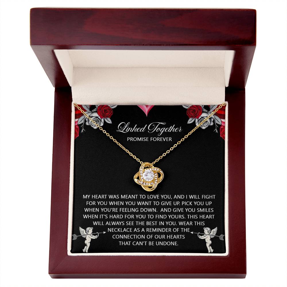 The Soulmate-To Find Yours - Love Knot Necklace showcases a gemstone and cubic zirconia crystals in a wooden box. Its gold finish is complemented by a decorative card inside the lid bearing a heartfelt message.