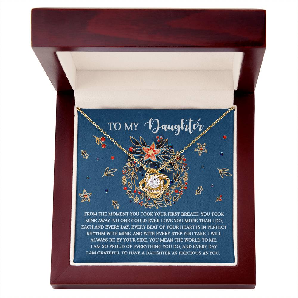 The Daughter-Perfect Rhythm - Love Knot Necklace, featuring sparkling cubic zirconia crystals and presented in a wooden box with an ornate floral design, comes with a heartfelt message for a daughter.