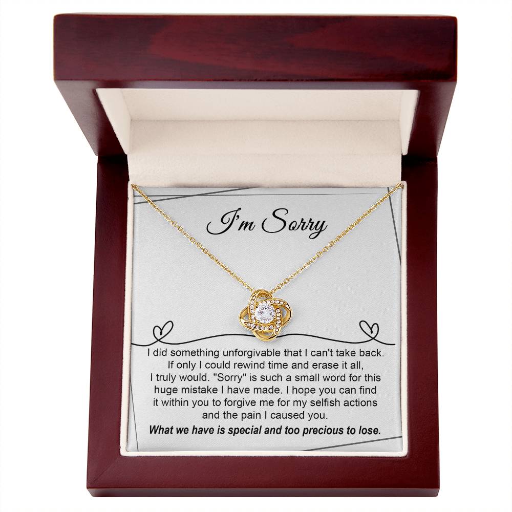 The Sorry-Breaking My Heart - Love Knot Necklace, featuring a gold finish and embellished with sparkling cubic zirconia crystals, is presented on a heartfelt message card that expresses deep regret for a mistake and seeks forgiveness.