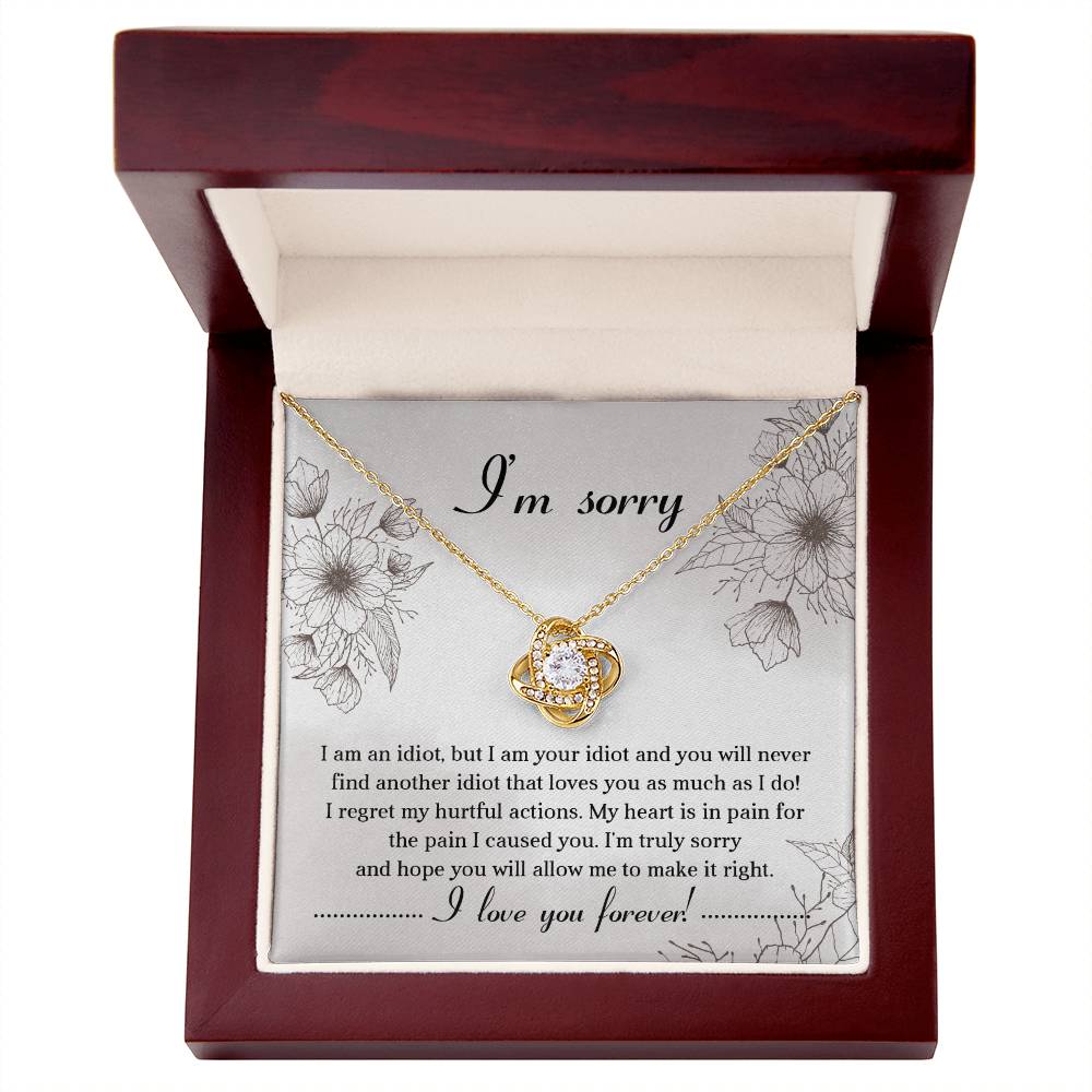 The Sorry-For The Pain - Love Knot Necklace is a personalized gift featuring a love knot pendant adorned with cubic zirconia crystals, presented on a card with an apology message expressing regret and a heartfelt plea for forgiveness, ending with "I love you forever!