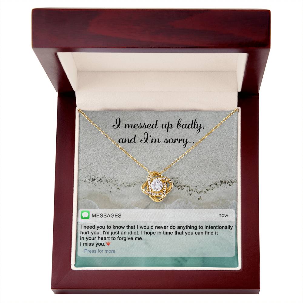 The "Sorry-Just An Idiot - Love Knot Necklace" features a heart-shaped pendant adorned with cubic zirconia crystals, presented on a card inscribed with "I messed up badly, and I'm sorry." It comes complete with a heartfelt text message expressing deep remorse and seeking forgiveness.