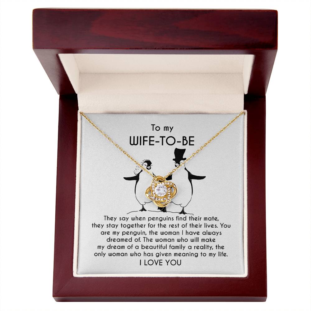 A silver *To Wife-to-be, My Penguin - Love Knot Necklace* with a flower-like pendant is displayed on a jewelry card. The card contains a message to a "Wife-To-Be" featuring a heartfelt dedication and illustrations of two penguins.