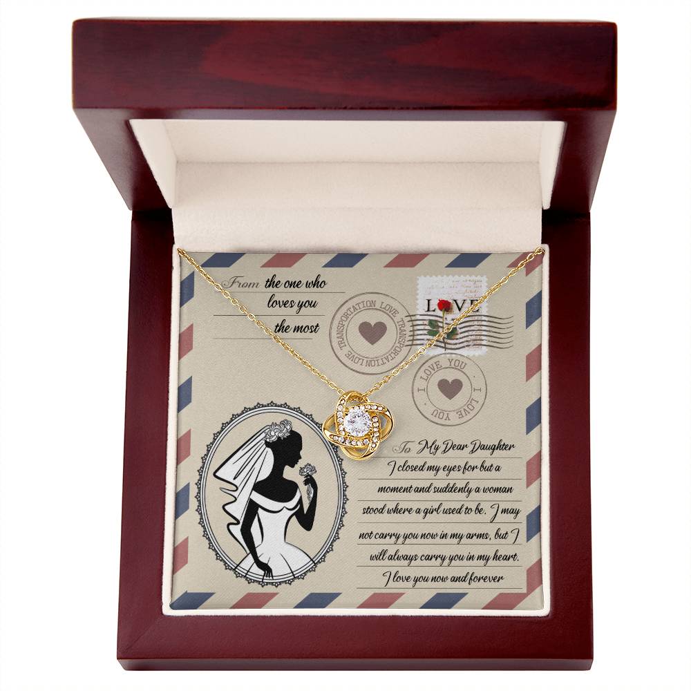 A To Daughter Wedding, In My Arms - Love Knot Necklace with a heart-shaped pendant on a card with a vintage design, featuring cubic zirconia crystals, a silhouette of a woman in a wedding gown, and a heartfelt message addressed to a daughter.