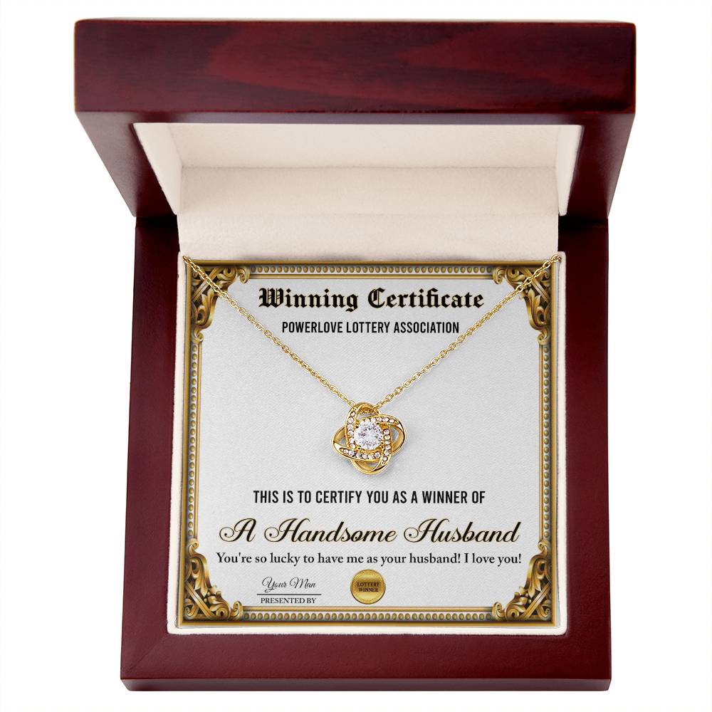 A "To Wife, Winning Certificate - Love Knot Necklace" is displayed against a certificate text background reading, "Winning Certificate - Powerlove Lottery Association - A Handsome Husband," featuring shimmering cubic zirconia crystals and an elegant gold finish.