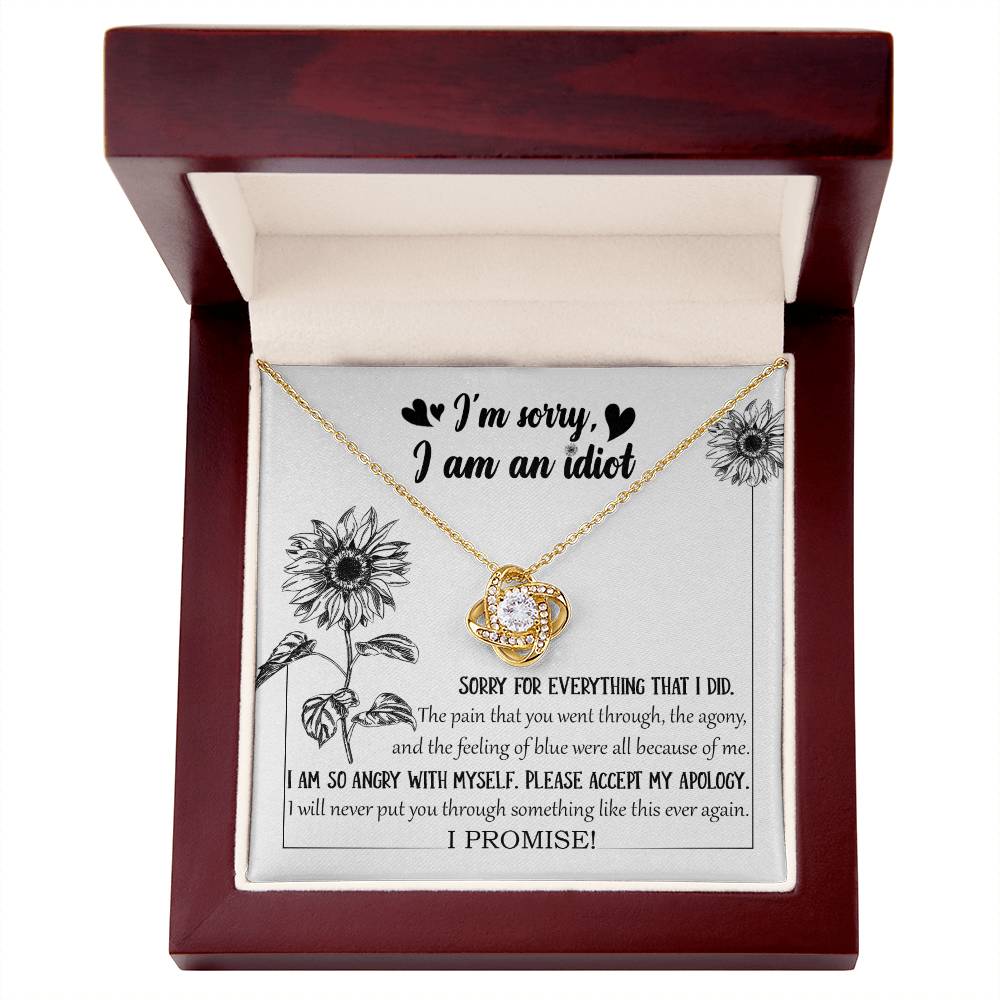 The Sorry-Feeling Of Blue - Love Knot Necklace, crafted from 14k white gold with a heart-shaped pendant adorned with cubic zirconia crystals, is displayed in a box containing an apology message, "I'm sorry, I am an idiot," along with additional text expressing regret for causing pain and a promise to not repeat the hurt.