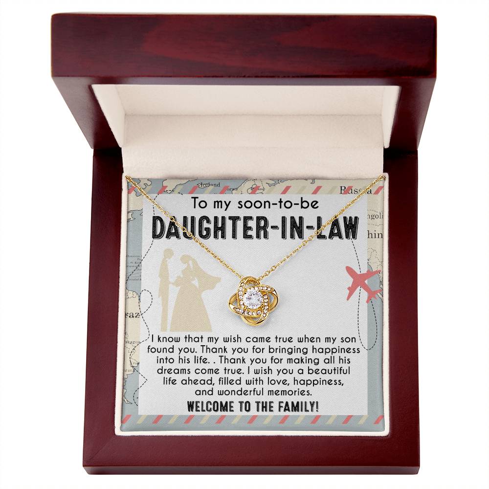 A To Daughter-in-Law, Into His Life - Love Knot Necklace with an intertwined design is displayed on a card that reads: "To my soon-to-be daughter-in-law. I wish you a beautiful life ahead, filled with love, happiness, and wonderful memories. Welcome to the family!" Available in white gold or yellow gold finish.