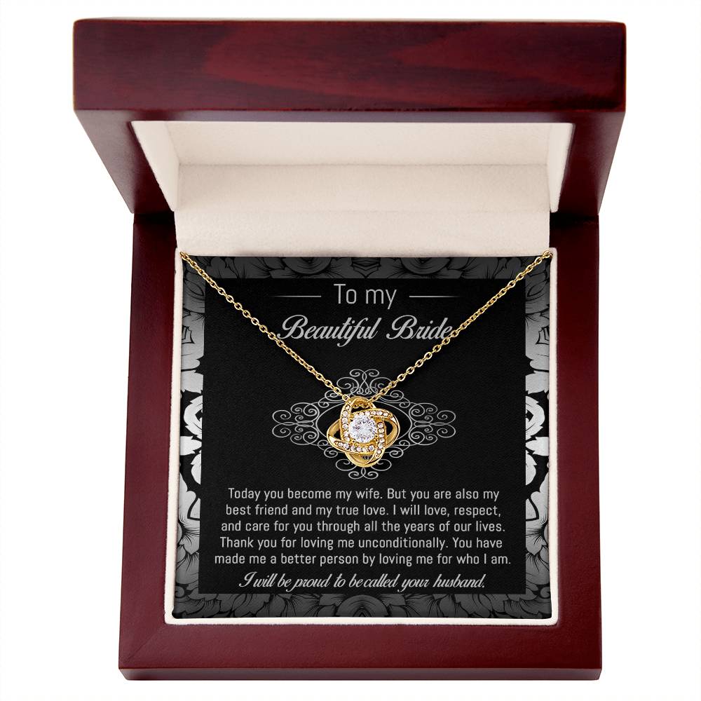 The "To Bride, My True Love - Love Knot Necklace" with a diamond pendant is displayed in a black and white box adorned with a floral pattern. The box, featuring cubic zirconia crystals, includes a heartfelt message addressed to "my beautiful bride" from her husband.